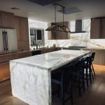Luxury kitchen featuring a backlit Cristallo quartzite island and backsplash at the Maru residence.