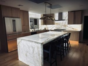 Luxury kitchen featuring a backlit Cristallo quartzite island and backsplash at the Maru residence.