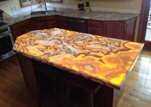 Lava onyx kitchen island with custom-shaped LED panel illumination