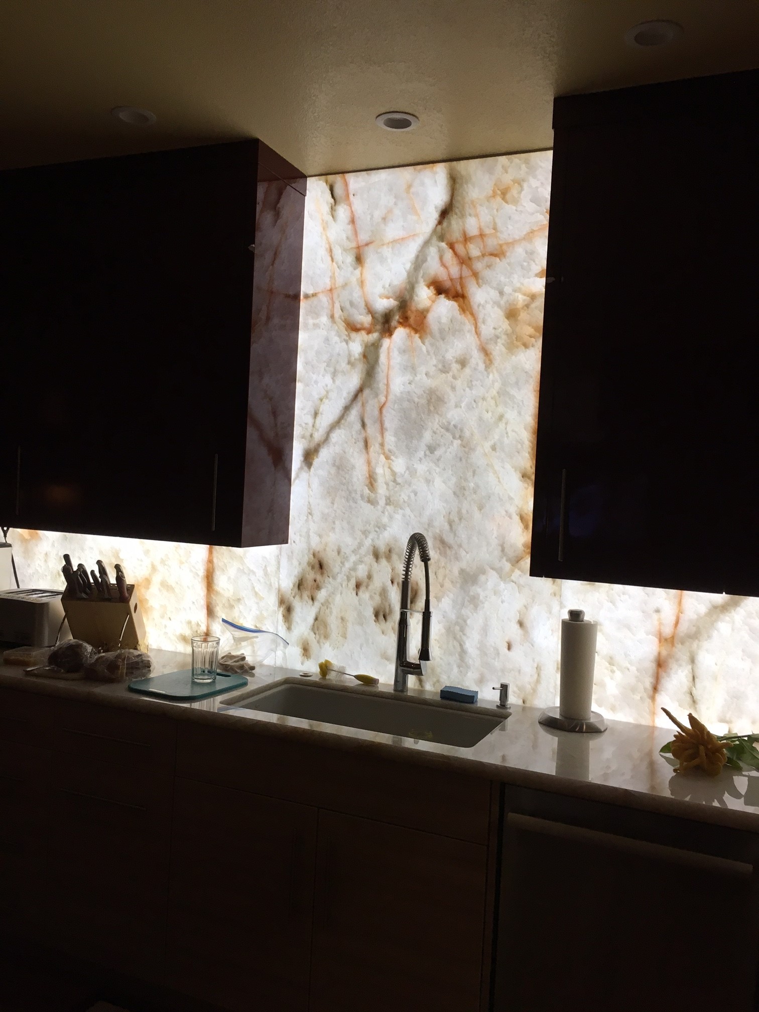 Backlit Cristallo Quartzite backsplash with glowing light panel in a Dallas kitchen