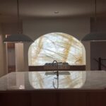 Backlit Cristallo Quartzite kitchen backsplash niche with warm LED lighting at the Manville Residence in Milton, Georgia
