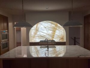 Backlit Cristallo Quartzite kitchen backsplash niche with warm LED lighting at the Manville Residence in Milton, Georgia