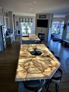 Dual backlit Cristallo Quartzite kitchen islands illuminated with custom frameless LED light panels at the Dowdie Residence in Braselton, Georgia.