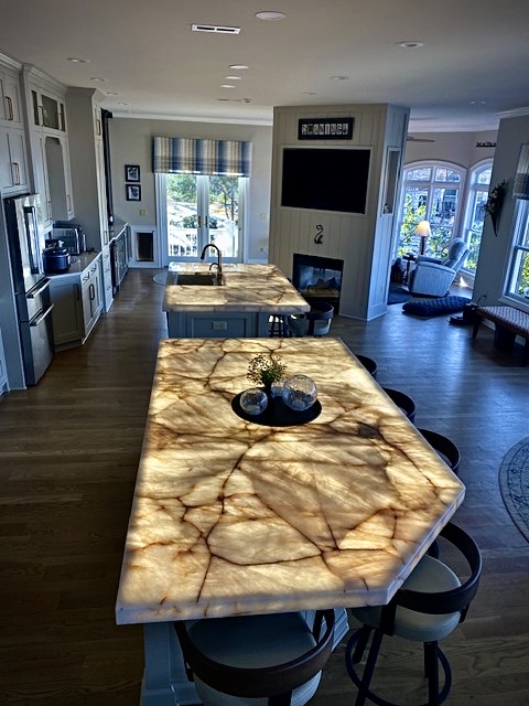 Dual backlit Cristallo Quartzite kitchen islands illuminated with custom frameless LED light panels at the Dowdie Residence in Braselton, Georgia.